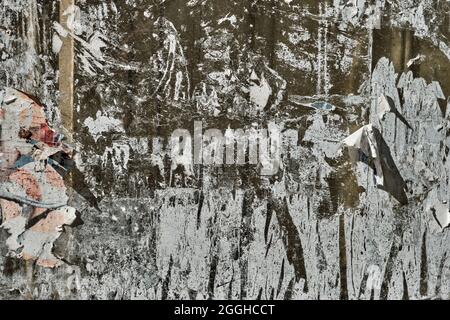 Peeled paper and adhesive rests in old bulletin board, grunge background or texture Stock Photo
