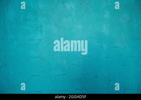 Turquoise colored wall with damp and cracking plaster Stock Photo