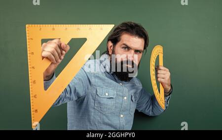 formal education. male student at mathematics school lesson. pass the math exam. learning the subject. serious man with beard using triangle ruler Stock Photo