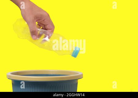 An empty plastic bottle in his hand is thrown into trash Stock Photo