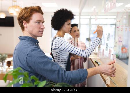 Diverse male and female colleagues working together, brainstorming, writing on memo notes Stock Photo