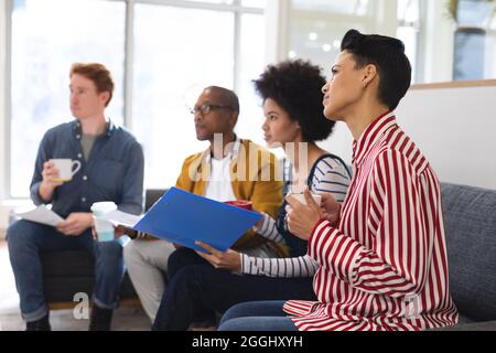 Diverse male and female colleagues working together, discussing in casual meeting Stock Photo