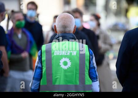 Cottbus, Germany. 01st Sep, 2021. A helper at the election campaign event of Bündnis 90/Die Grünen on Oberkirchplatz wears a green high-visibility vest with the gender-appropriate inscription 'Ordner*in' ('Steward') during the event. Credit: Soeren Stache/dpa-Zentralbild/dpa/Alamy Live News