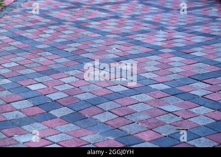 Colorful cobblestone road pavement and lawn divided by a concrete curb. Stock Photo