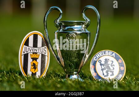 August 27, 2021 Turin, Italy. The emblems of football clubs Chelsea F.C. London and Juventus F.C. Turin and the UEFA Champions League Cup on the green Stock Photo