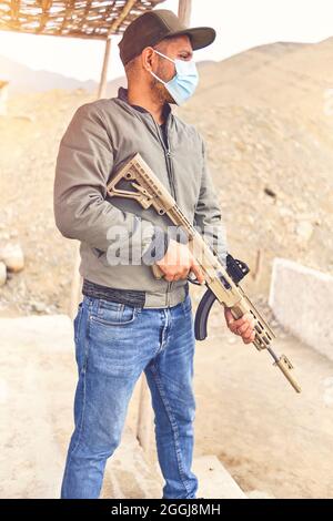 Men practicing shooting with a assault rifle at target. Selective Focus Stock Photo