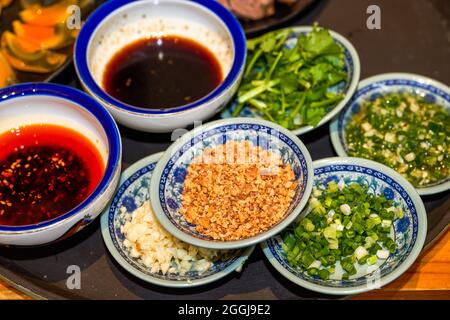 Various seasonings for hot pot, crushed peanuts, shallots, soy sauce, chili Stock Photo