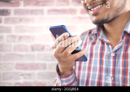 happy young man hand using smart phone. Stock Photo