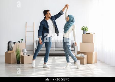 Loving arabic family dancing in new apartment Stock Photo