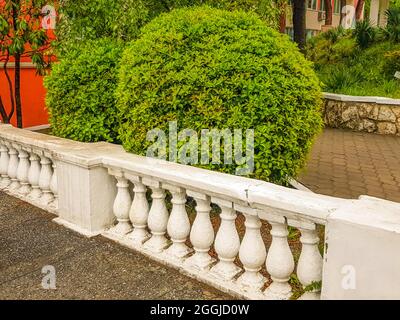 A stone staircase with a railing with balustrades descends into the ...