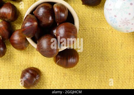 portuguese nuts in ceramic container on table with yellow jute Stock Photo