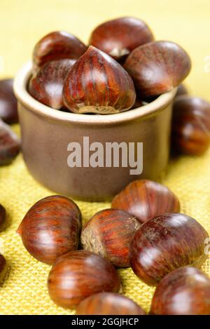 portuguese nuts in ceramic container on table with yellow jute Stock Photo