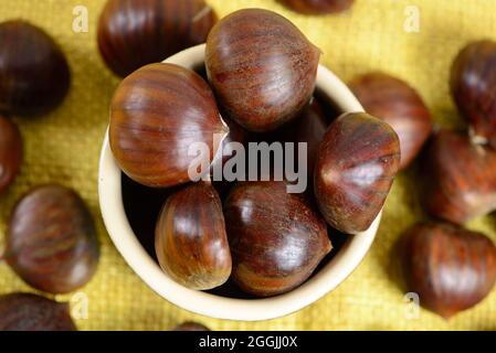 portuguese nuts in ceramic container on table with yellow jute Stock Photo