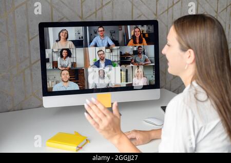 Webinars, online conference, video meeting. A businesswoman is using app on laptop for video connect with a many people at same time together. Distant work concept Stock Photo