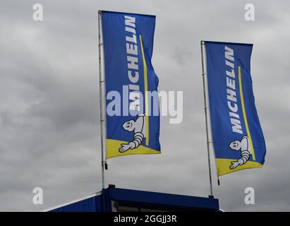 Two Michelin flags fluttering in the wind on a grey English summers day Stock Photo