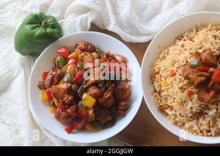 Chilli Chicken Made with Marinated and air fried chicken chunks in a dry gravy of onions bell peppers and sauces. Served with fried rice. A popular In Stock Photo