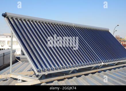 Modern House Roof with Solar Water Heater, Solar Panels as energy efficiency solution. Vacuum solar water heating system. Stock Photo