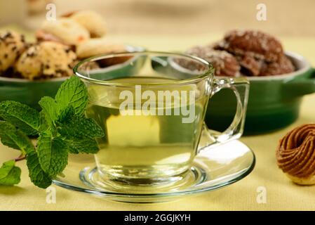 mint tea in transparent cup with sweet cookies around Stock Photo