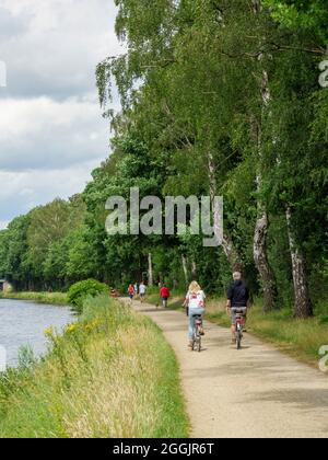 Riverside path with cyclists, branch canal Osnabrück, Osnabrücker Land, Lower Saxony, Germany Stock Photo