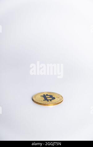 One Bitcoin golden coin color with the letter 'B' on Blue color, faced down and centered in a light grey background. Stock Photo