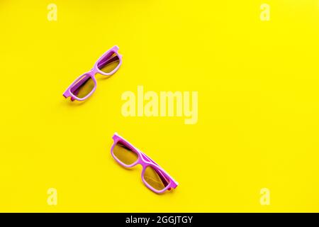 A pair of 3d glasses for watching a movie lie on a bright yellow background. Stock Photo