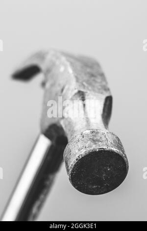 A black and whiteportrait of the top part of the face a metal claw hammer isolated on a background. The tool is a bit worn by using it for work in con Stock Photo