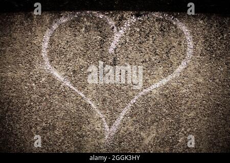 Pale pink love heart spray painted onto rendered concrete surface. Stock Photo