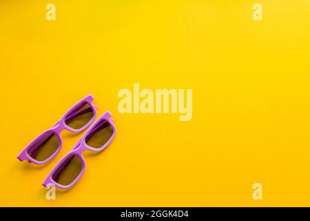 The 3d glasses for watching a movie lie on a yellow background. Stock Photo