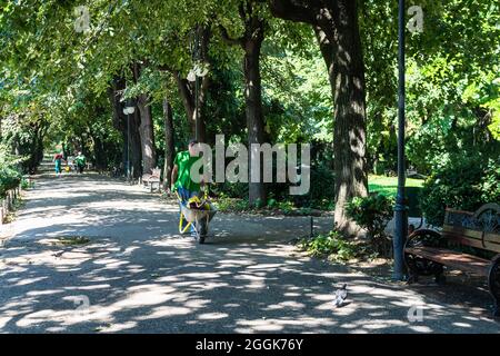 Maintenance of public park and gardens. Municipal workers cleaning public park Cismigiu Gardens in Bucharest, Romania, 2021 Stock Photo