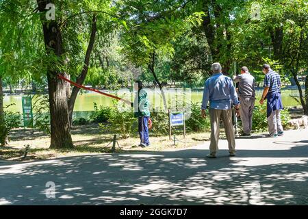 Maintenance of public park and gardens. Municipal workers cleaning public park Cismigiu Gardens in Bucharest, Romania, 2021 Stock Photo
