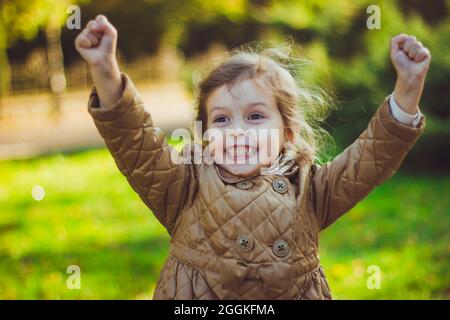 A little girl holding her hands up Stock Photo