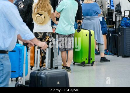 Duesseldorf, North Rhine-Westphalia, Germany - Duesseldorf Airport, holiday start in NRW, vacationers stand with suitcases in a queue at the check-in counter in times of the corona pandemic on their way to summer vacation. Stock Photo