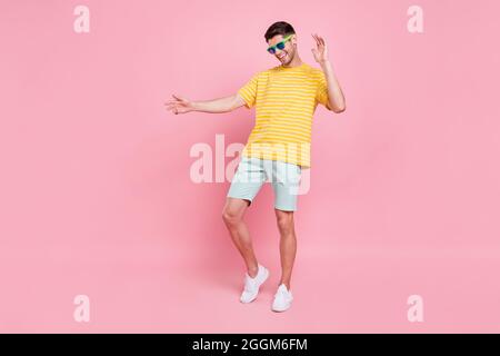 Full body photo of cheerful young happy man dance wear sunglass vacation summer isolated on pink color background Stock Photo