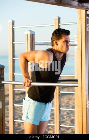 Male athlete doing dips on parallel bars Stock Photo