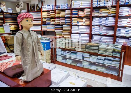United Arab Emirates UAE Dubai,Deira Al Rigga,Al Ghurair Centre,shopping fabric shop store business,doll Bedouin Arab thawb robe keffiyeh Stock Photo