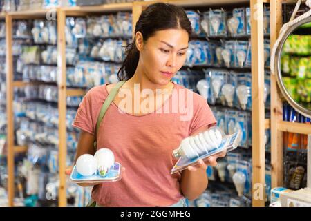 Asian female selecting energy efficient light bulbs Stock Photo