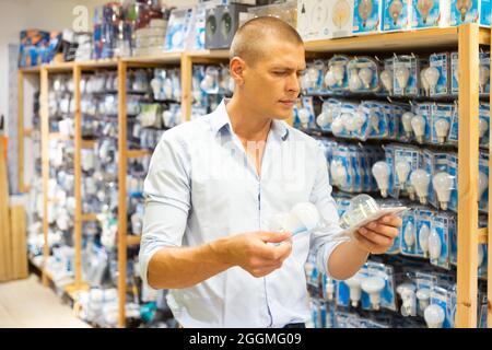 Man choosing energy saving light bulbs Stock Photo