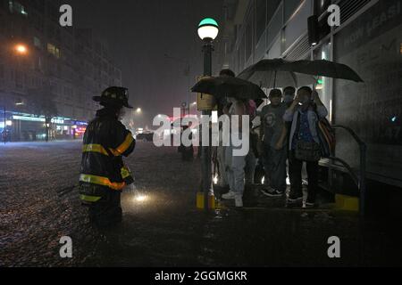 New York City, USA. 01st Sep, 2021. A member of the FDNY directs people stranded at a subway entrance during flash flooding caused by storm Ida in the New York City borough of Queens, NY, September 1, 2021. (Photo by Anthony Behar/Sipa USA) Credit: Sipa USA/Alamy Live News Stock Photo