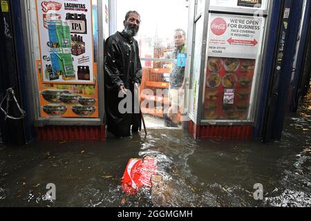 New York City, USA. 01st Sep, 2021. A homeless man stands in the doorway of a deli during flash flooding caused by storm Ida in the New York City borough of Queens, NY, September 1, 2021. (Photo by Anthony Behar/Sipa USA) Credit: Sipa USA/Alamy Live News Stock Photo