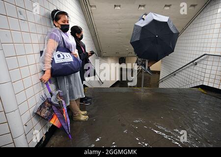 New York City, USA. 01st Sep, 2021. People stand inside a subway station as water runs past their feet during flash flooding caused by storm Ida in the New York City borough of Queens, NY, September 1, 2021. (Photo by Anthony Behar/Sipa USA) Credit: Sipa USA/Alamy Live News Stock Photo