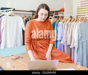 Female fashion designer creating clothing design online on laptop Stock Photo