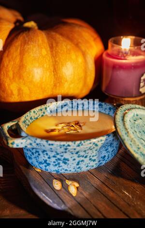 Halloween with candles with pumpkin and cream soup on spooky night - Halloween scene Stock Photo