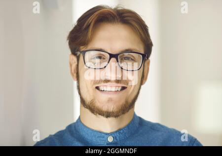 Portrait of happy young office worker or businessman in glasses smiling at camera Stock Photo