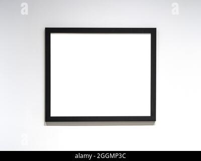 Photo frame mockup, black frame with white blank sheet on the wall. Space for text. Stock Photo