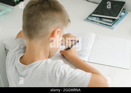 Caucasian schoolboy boy doing school homework. Homeschooling concept Stock Photo