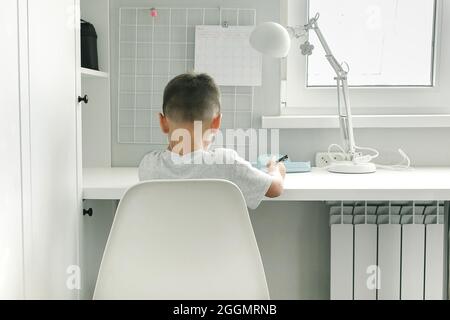Concept of study distant from home. Caucasian boy doing school homework. Distance learning, online education Stock Photo
