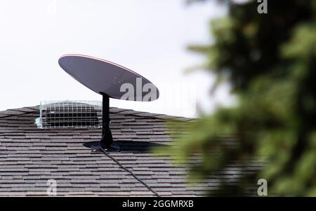 SpaceX Starlink satellite internet receiver seen installed on the roof of a home in a rural Canadian community. Stock Photo