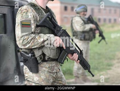 Soldiers with assault rifle and flag of Lithuania on military uniform. Collage. Stock Photo