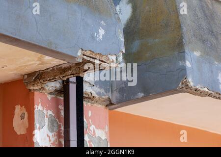 Wall with cracked concrete and rusty irons requiring renovation. Stock Photo