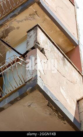 Balconies with cracked concrete and rusty irons requiring renovation. Stock Photo